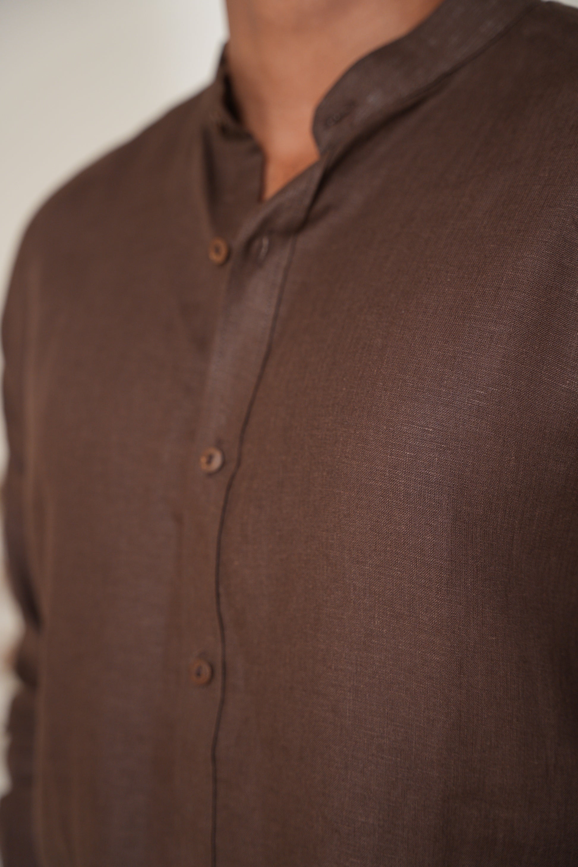 Close-up of a rich brown raglan sleeve shirt, showcasing the smooth fabric and flattering fit with contrasting sleeves.