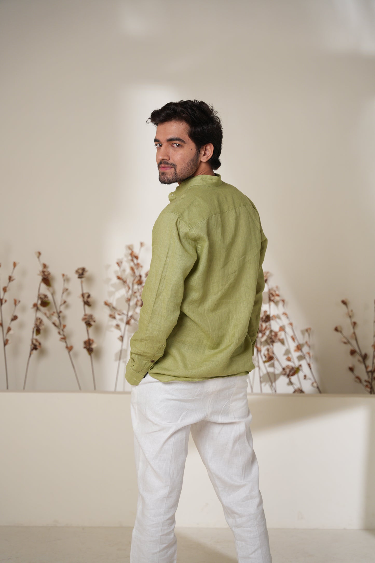 Close-up of a plain sage green short kurta, highlighting the smooth fabric and classic collar.