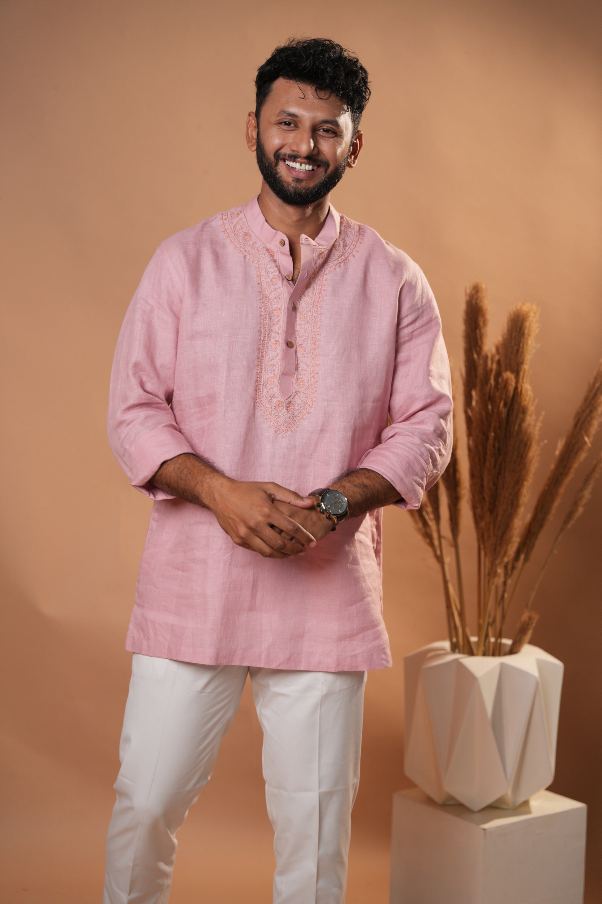 Soft pink Chikankari short kurta with delicate hand-embroidered floral patterns.