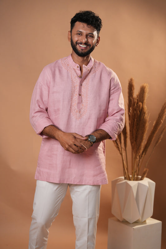 Soft pink Chikankari short kurta with delicate hand-embroidered floral patterns.