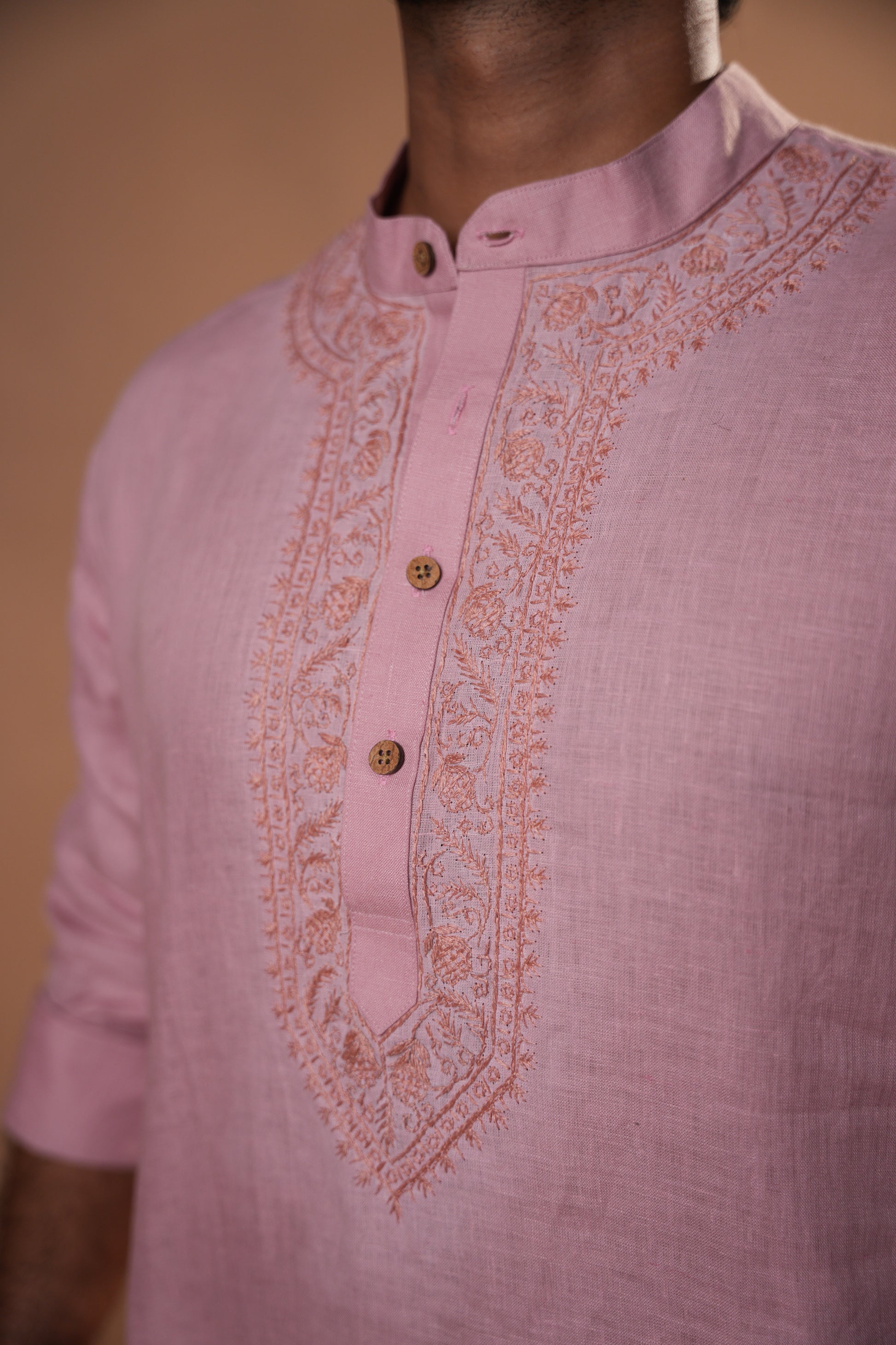 Men’s Chikankari short kurta in soft pink, crafted with intricate threadwork on lightweight fabric.