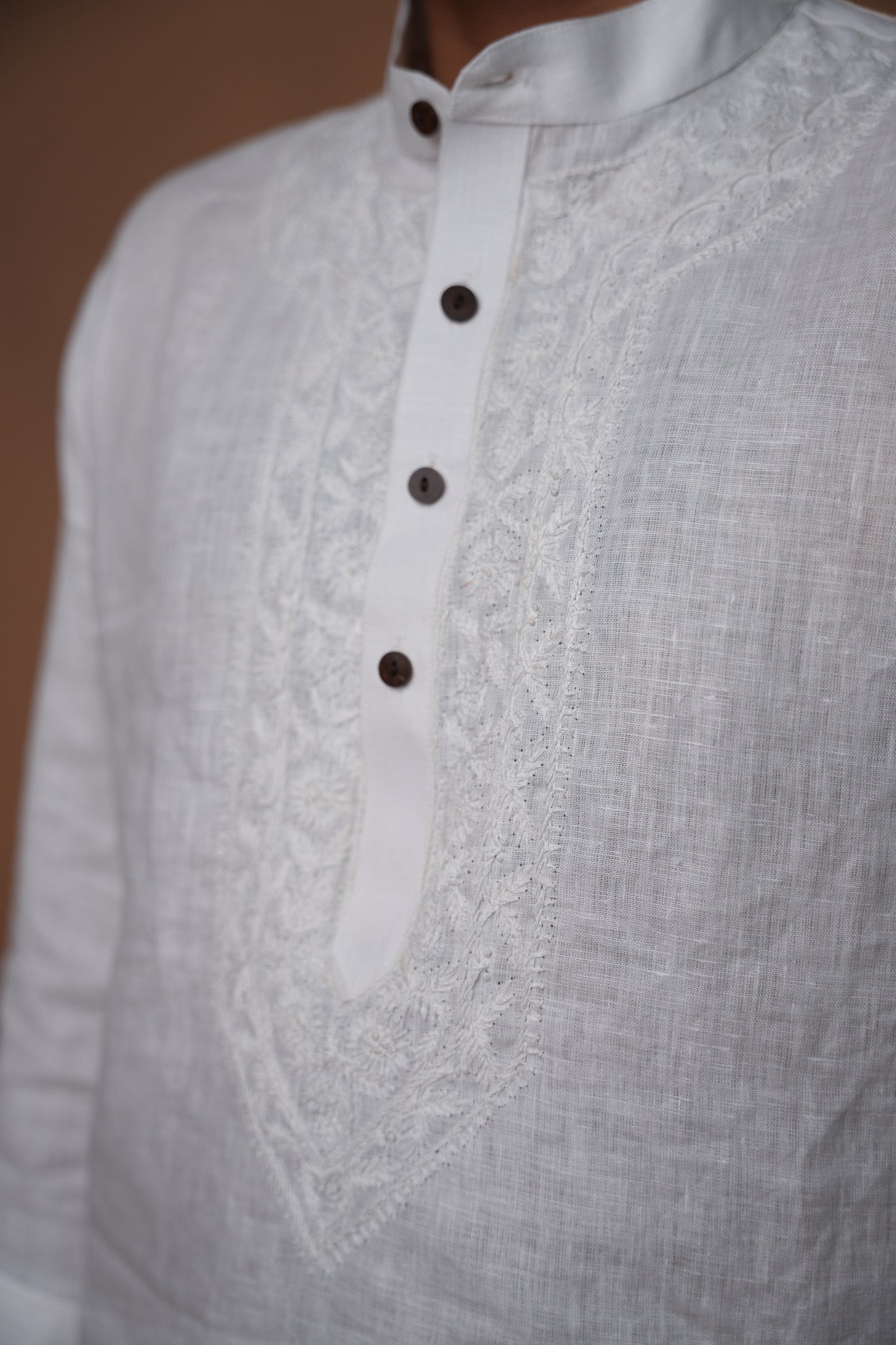 Men’s Chikankari short kurta in pure white, showcasing fine traditional embroidery on lightweight fabric.