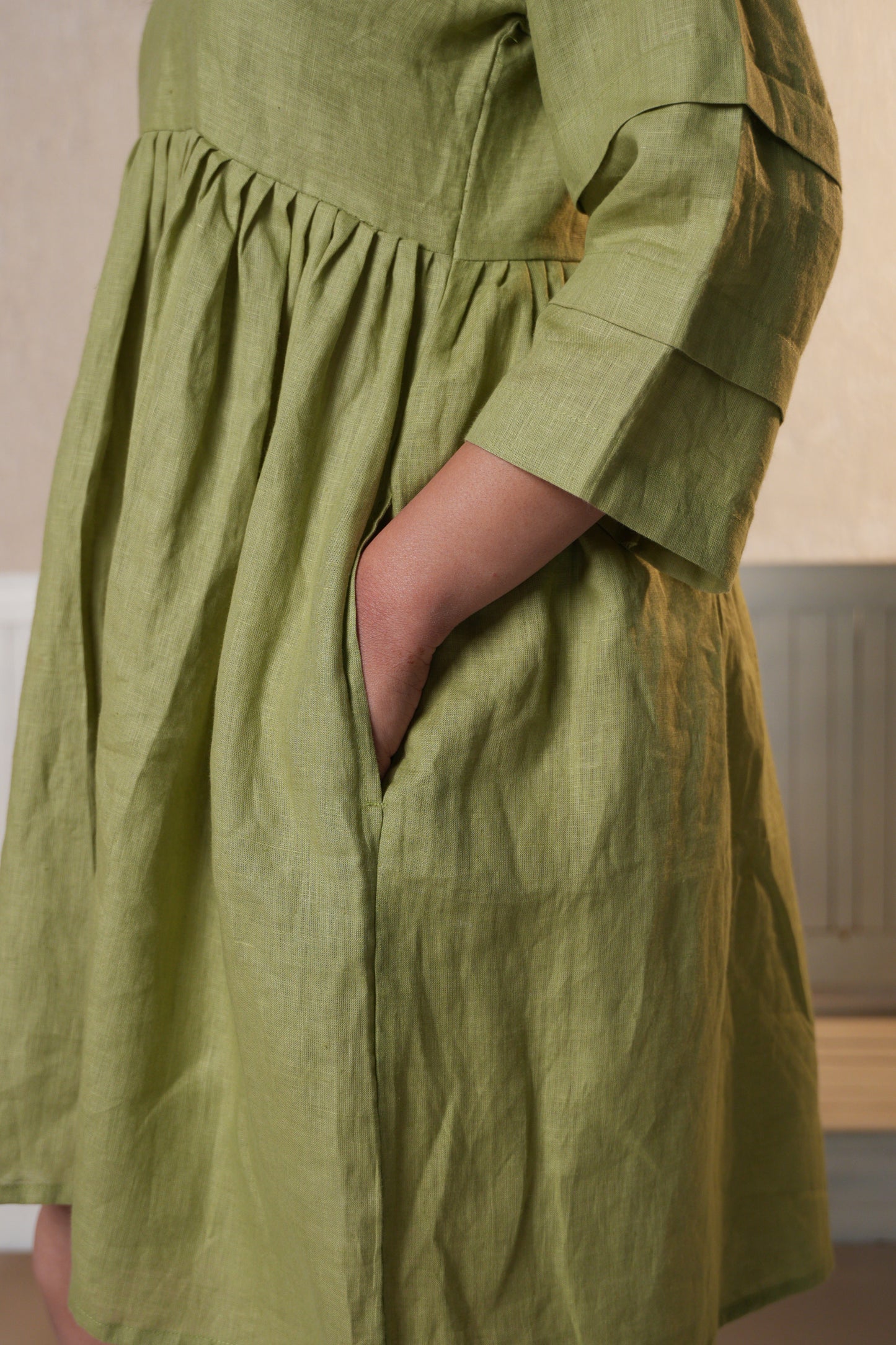 Close-up of a pleated sleeve dress, showcasing the intricate pleating on the sleeves and the smooth, flowing fabric.